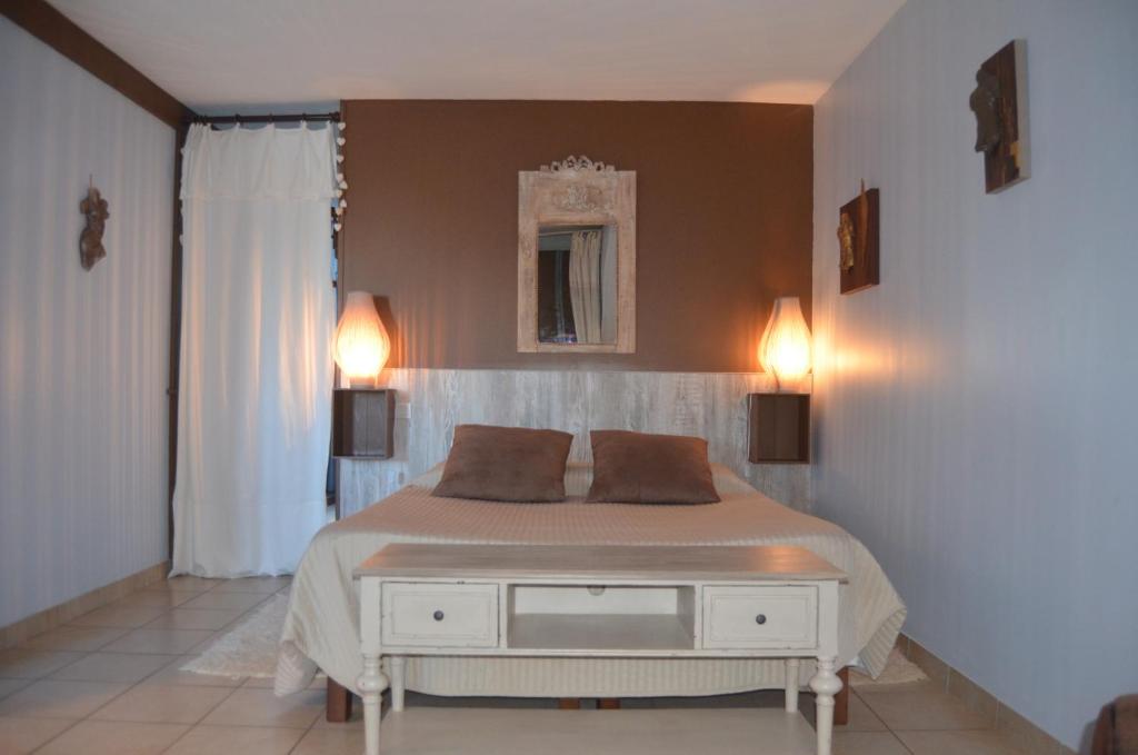 a bedroom with a bed and two lights on the wall at LA MAISON DU PECHEUR in Chaumont-sur-Loire