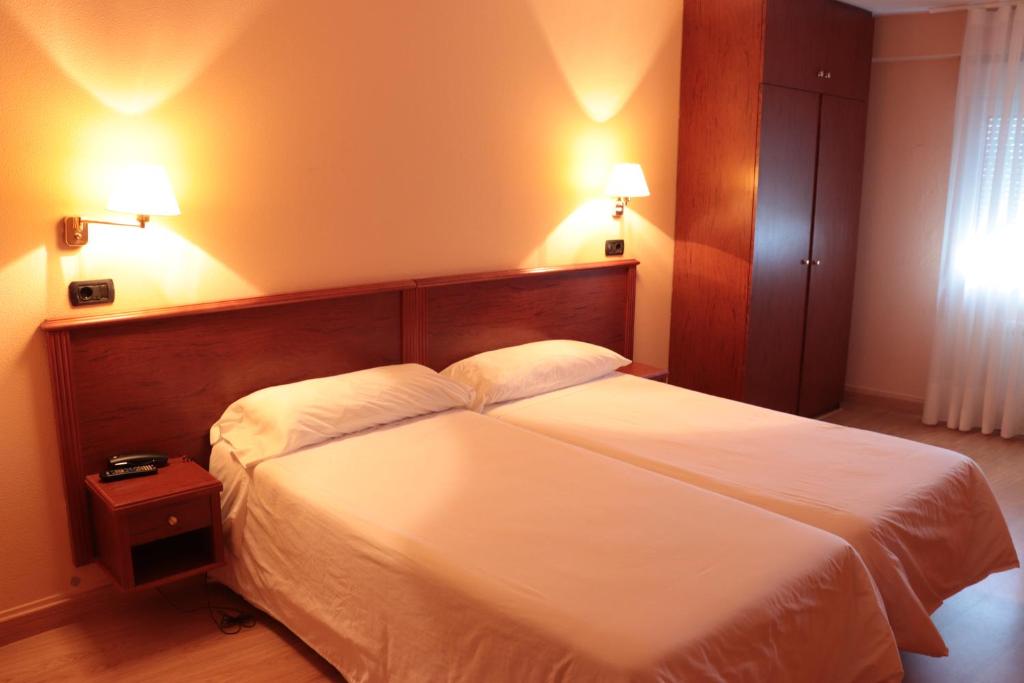 
a hotel room with two beds and a lamp at Hotel Maycar in A Coruña

