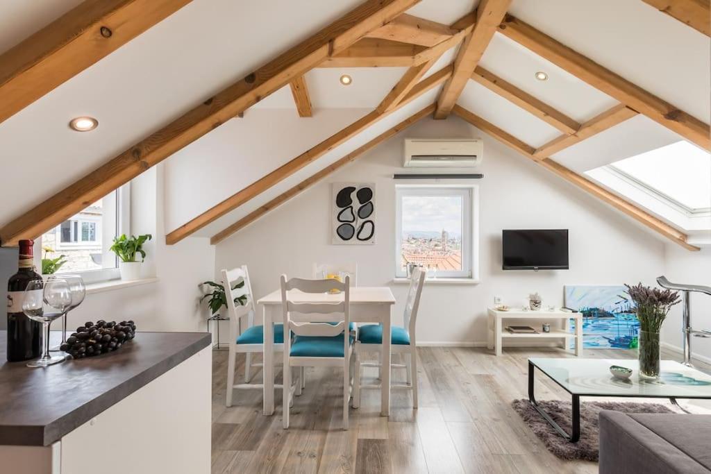 a kitchen and living room with a table and chairs at Guest House Kala in Split