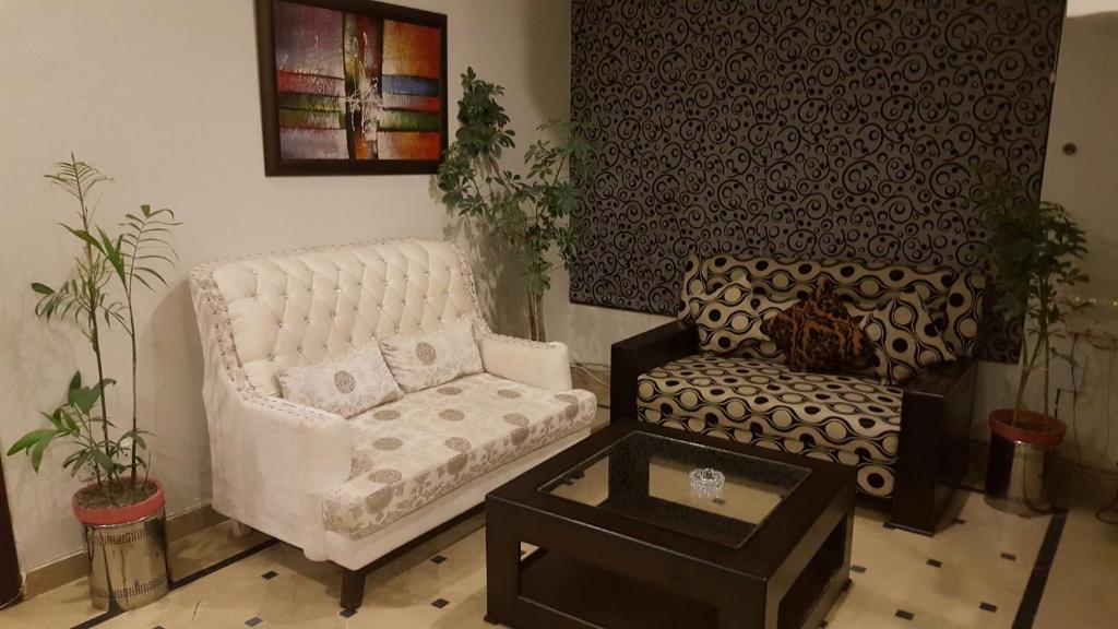 ein Wohnzimmer mit einem Sofa und einem Stuhl in der Unterkunft Mulberry Residence Family Rooms in Islamabad
