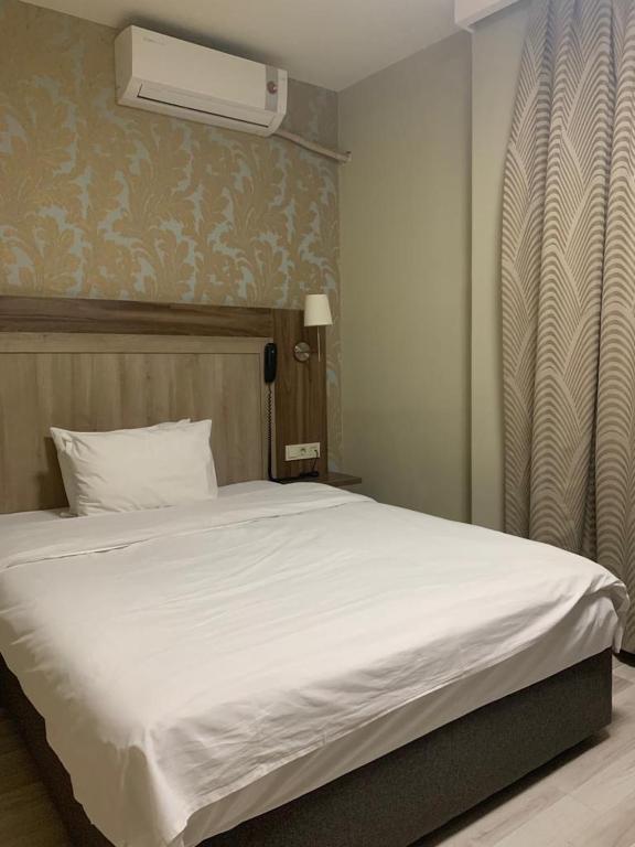 a bedroom with a white bed and a air conditioner at Venus Hotel Taksim in Istanbul