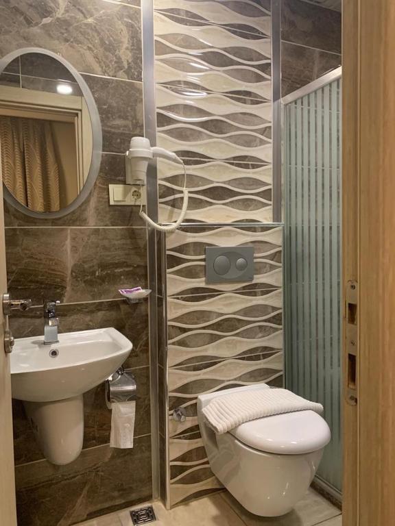 a bathroom with a toilet and a sink and a mirror at Venus Hotel Taksim in Istanbul