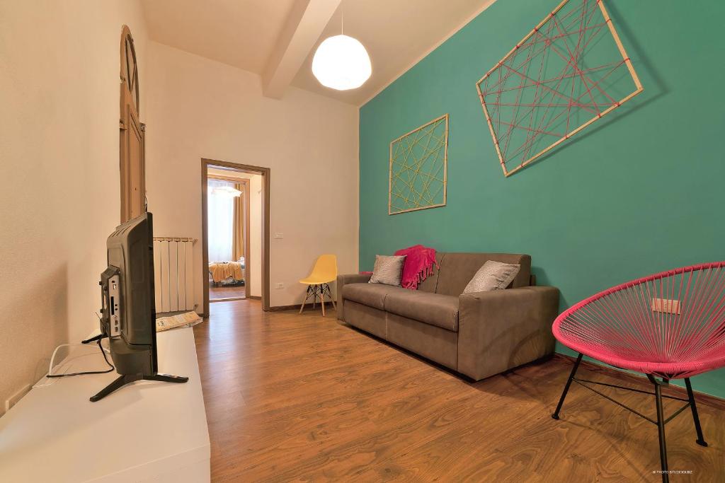 salon z kanapą i telewizorem w obiekcie Borgo in color - Sweet Dreams in Florence we Florencji