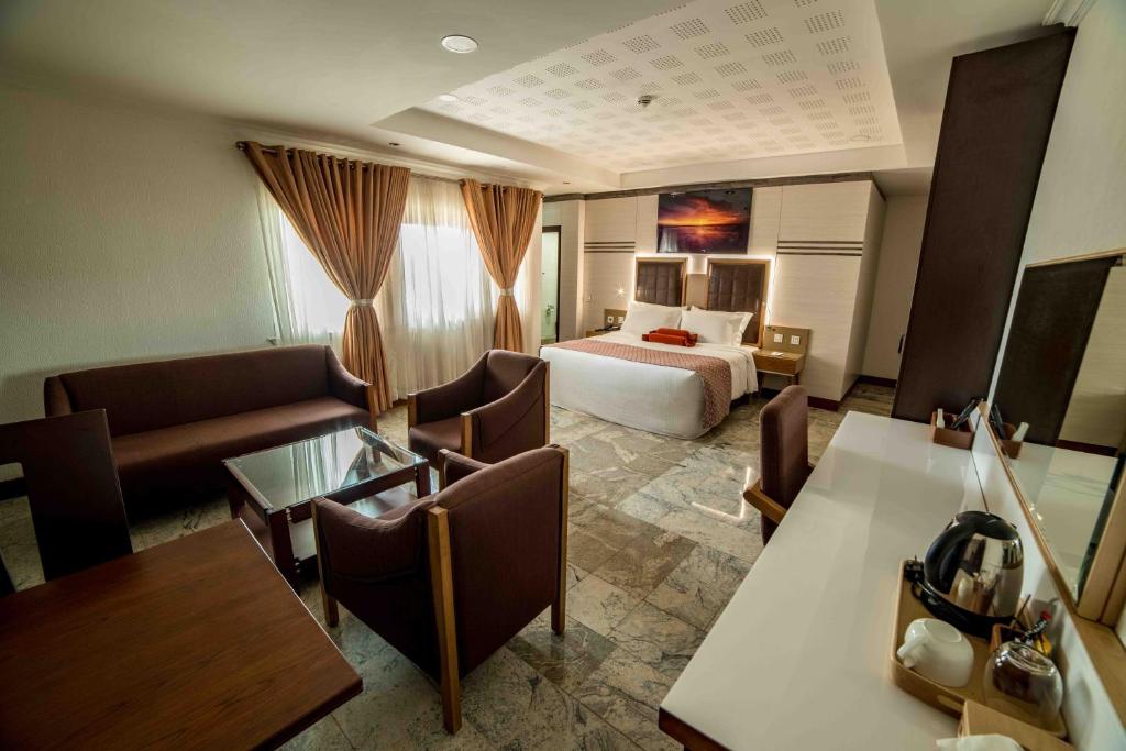 a hotel room with a bed and a living room at AlphaPlus Apartment 91 in Abuja