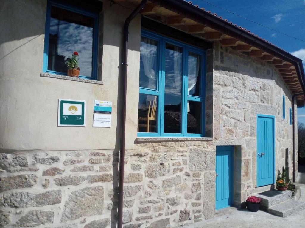 Casa Antoni@ في بارادا ديل سيل: منزل حجري بأبواب ونوافذ زرقاء