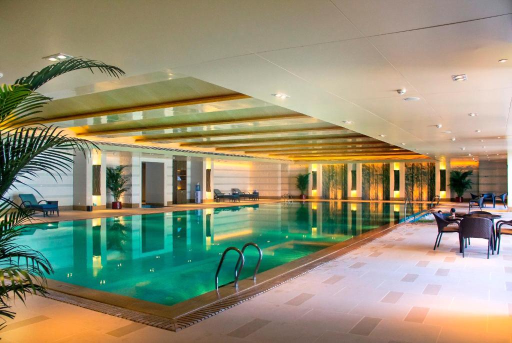 a large swimming pool in a hotel lobby at Grand Hotel Haikou - Managed by Accor in Haikou