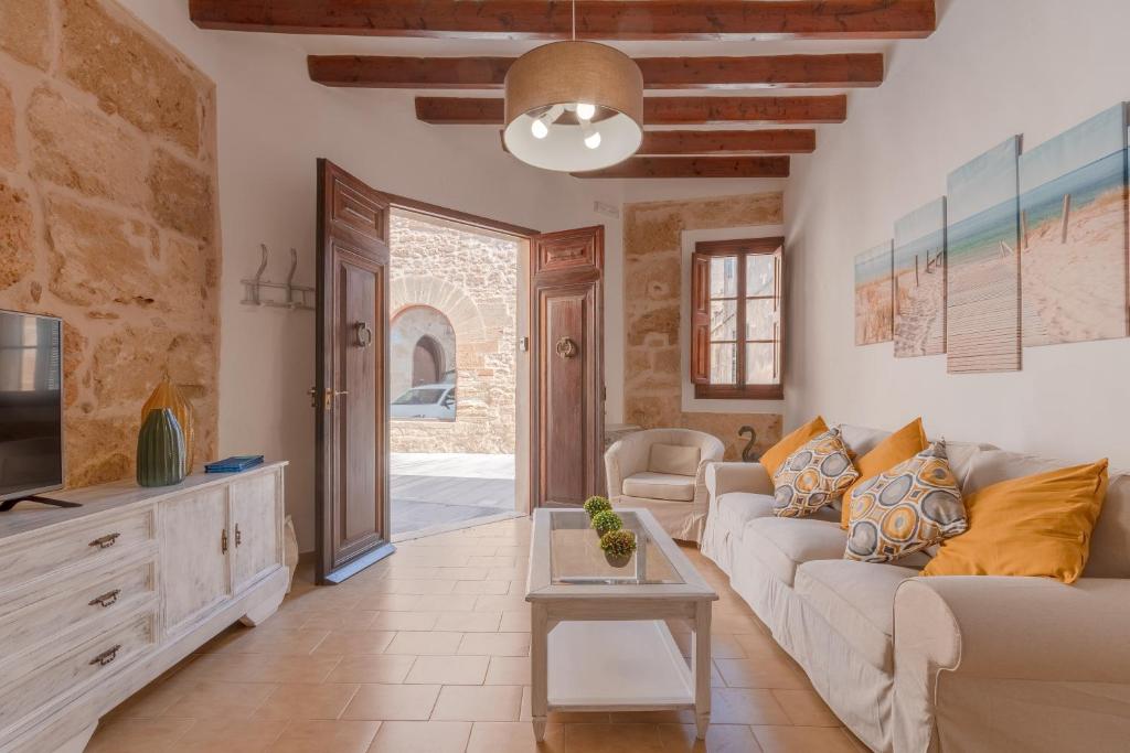 a living room with a couch and a tv at YupiHome Holiday Home Ca Na Serrieta in Alcudia
