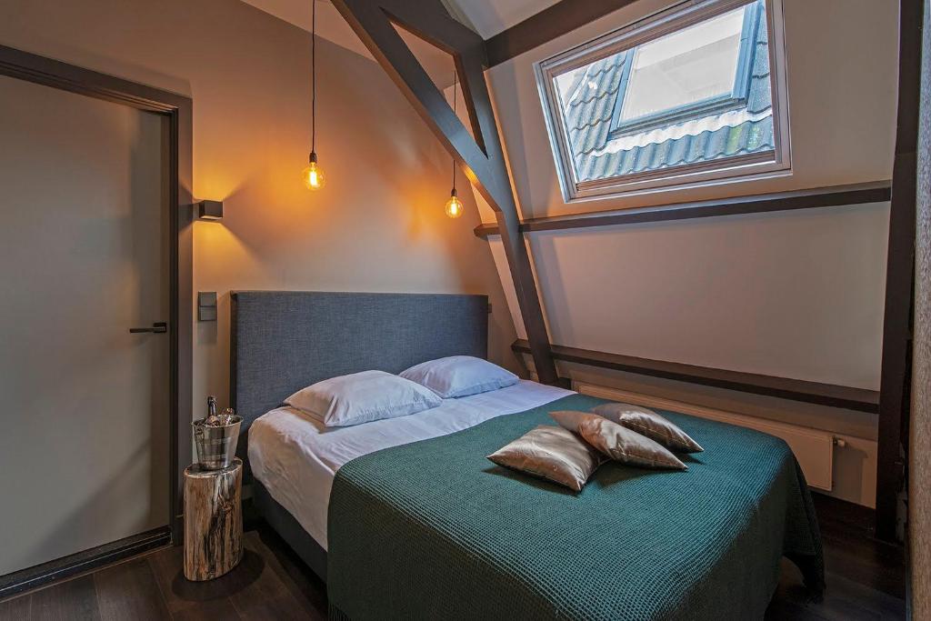 een slaapkamer met een bed met 2 kussens erop bij Loft Studio's in Zandvoort