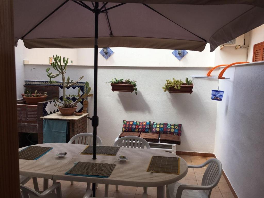 a table and chairs with an umbrella on a patio at San Vito Lo Capo Via Savoia 250 Casa vacanze in San Vito lo Capo