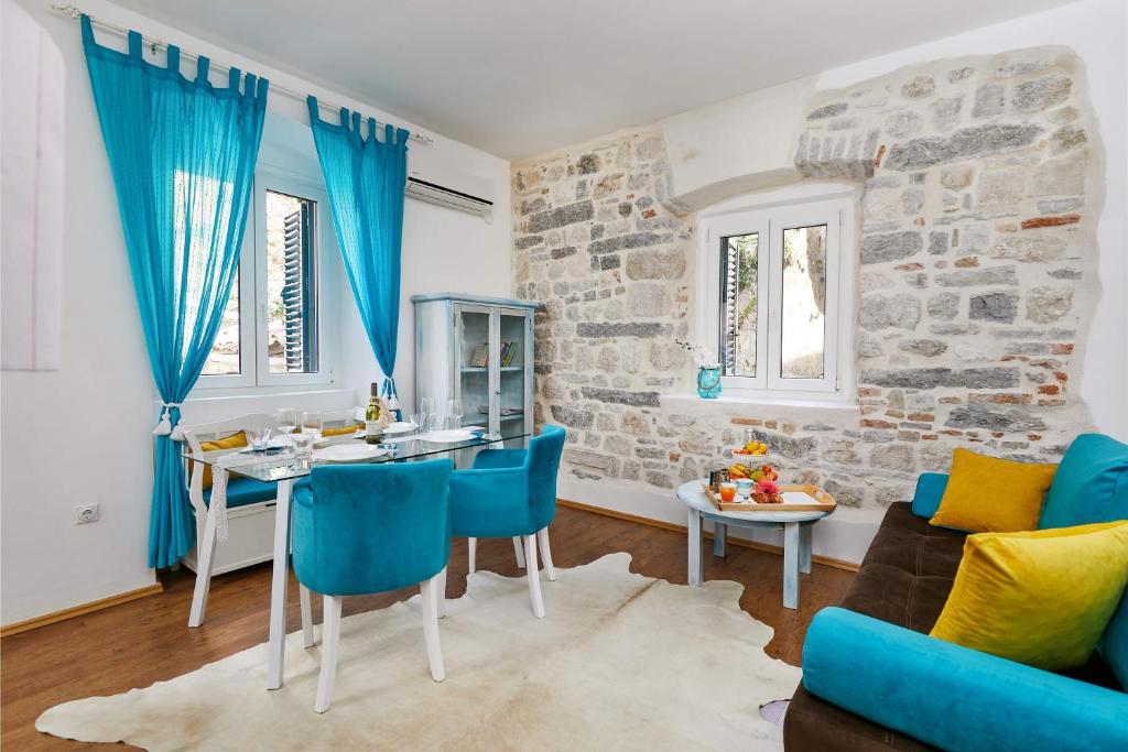 een woonkamer met een tafel en blauwe stoelen bij La Rocca Apartment Old Town Kotor in Kotor