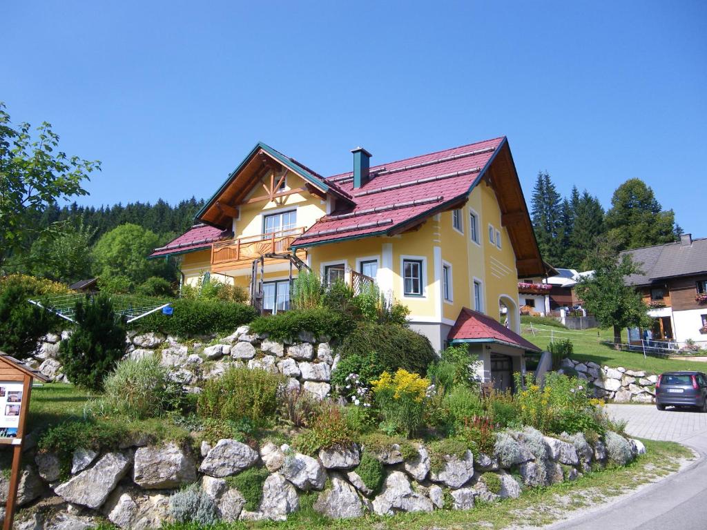ein gelbes Haus mit rotem Dach auf einem Hügel in der Unterkunft Haus ÖtscherTeufel in Lackenhof