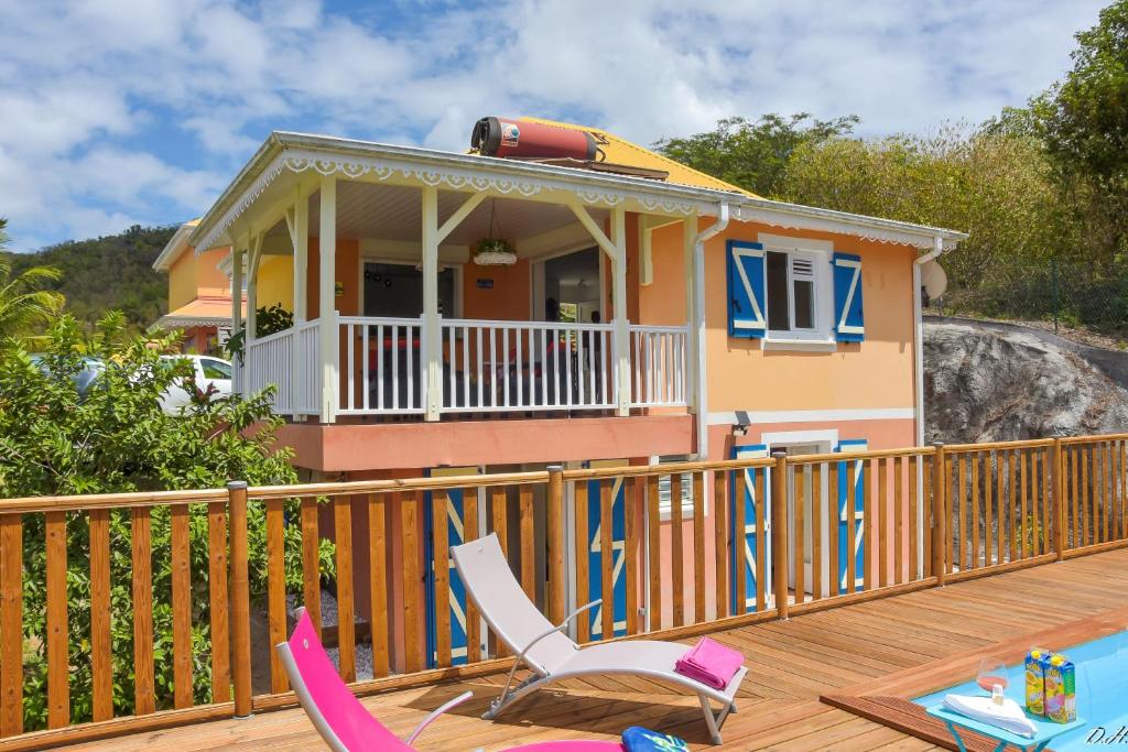 a deck with two chairs and a house at Villa Nord-Plage in Les Anses-dʼArlets