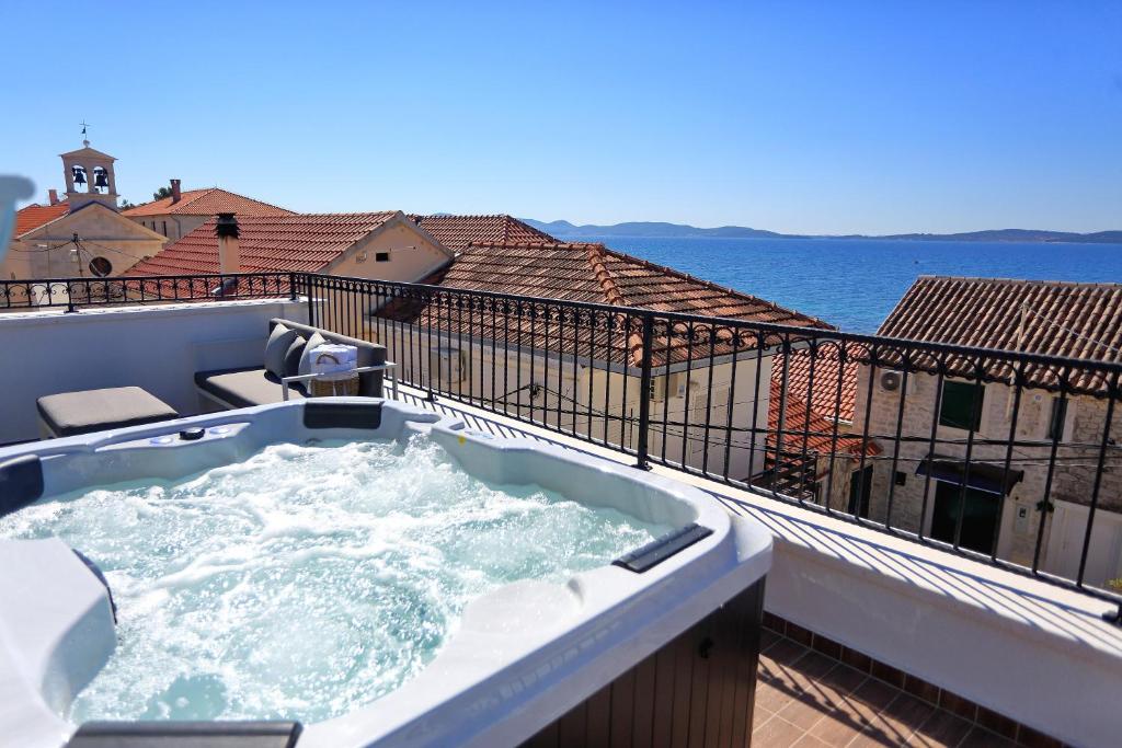 a hot tub on a balcony with a view of the ocean at Villa Vito in Bibinje