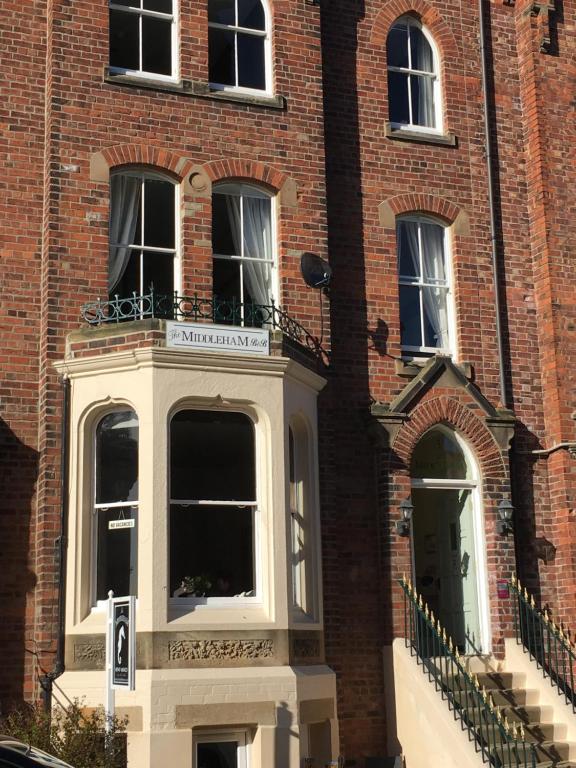 a brick building with a balcony on the front of it at The Middleham in Whitby