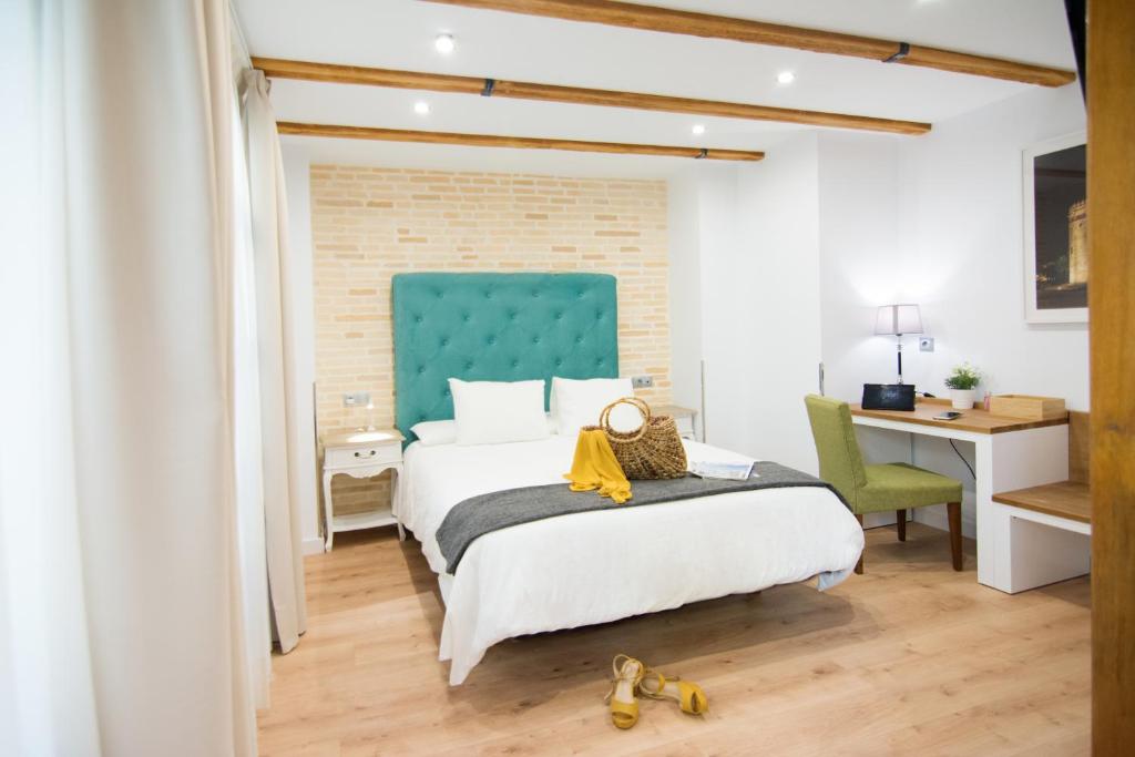 une chambre avec un lit avec une tête de lit bleue et un bureau dans l'établissement Acetres 5, à Séville