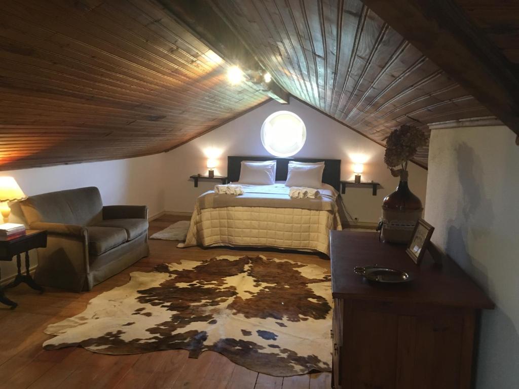 um quarto com uma cama, um sofá e uma mesa em Casa da Praia do Ribatejo em Praia do Ribatejo