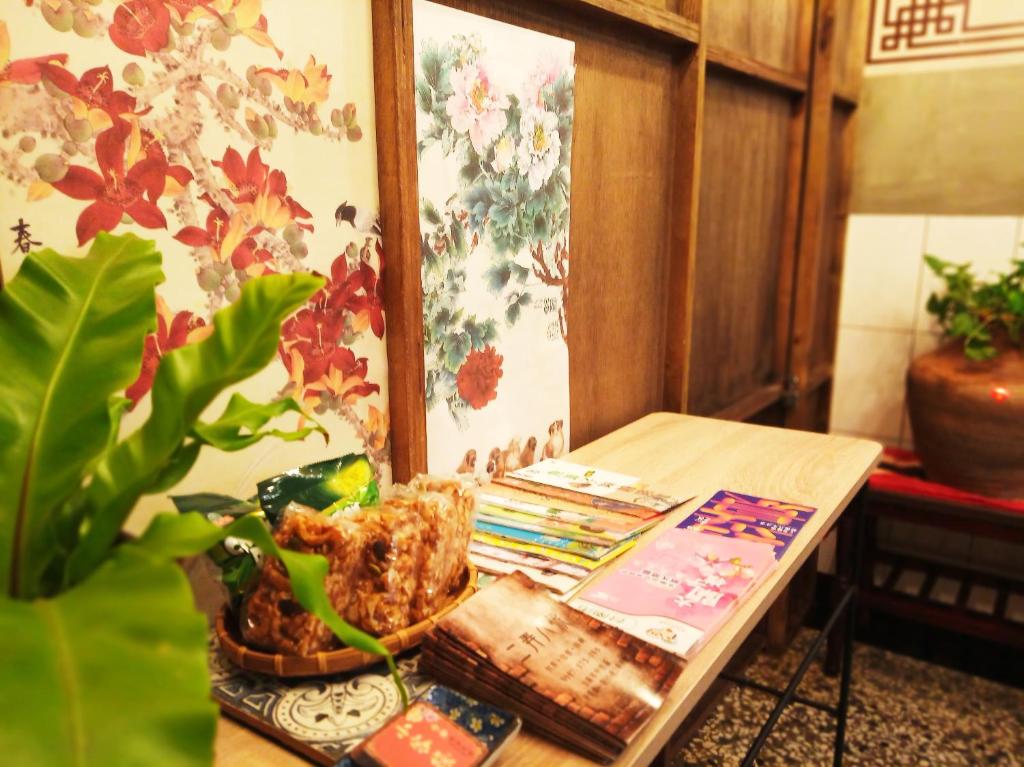 uma mesa com uma planta e livros sobre ela em Tainan-Inn em Tainan