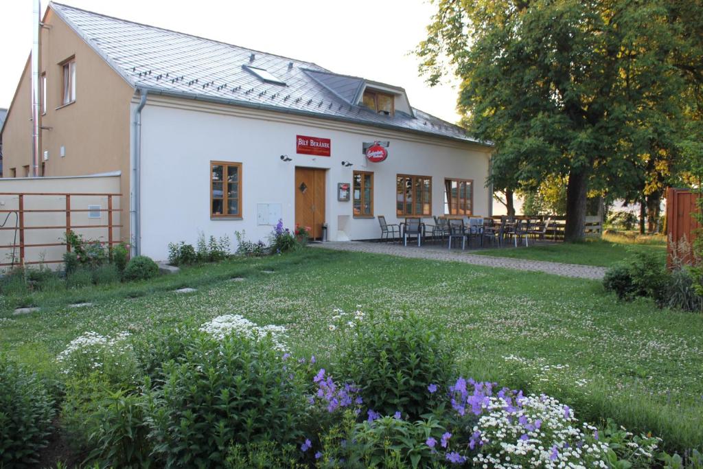 - un bâtiment blanc avec un jardin en face dans l'établissement Bílý Beránek, à Hladov