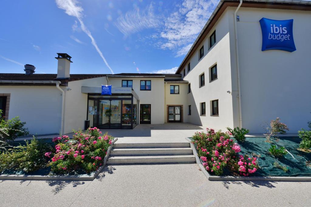 un bâtiment avec une enseigne sur le côté dans l'établissement ibis budget Marne la Vallée, à Saint-Thibault-des-Vignes