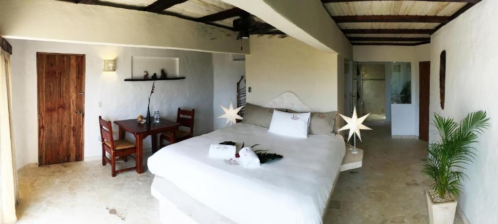 a bedroom with a large white bed and a desk at Cabrera Chalet boutique hotel in Cabrera