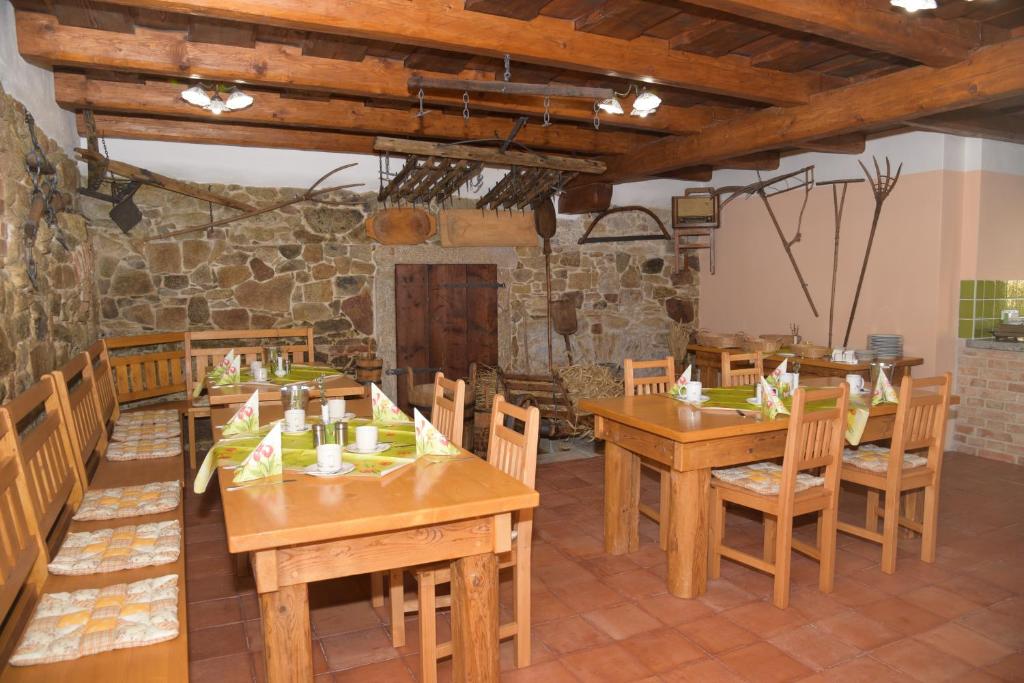 una sala da pranzo con tavoli e sedie in legno di U Slunecne brany a Františkovy Lázně