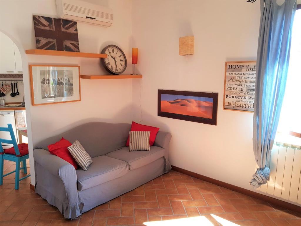 sala de estar con sofá y reloj en la pared en WelcHOME to Florence! Campo di Marte charming and bright, en Florencia