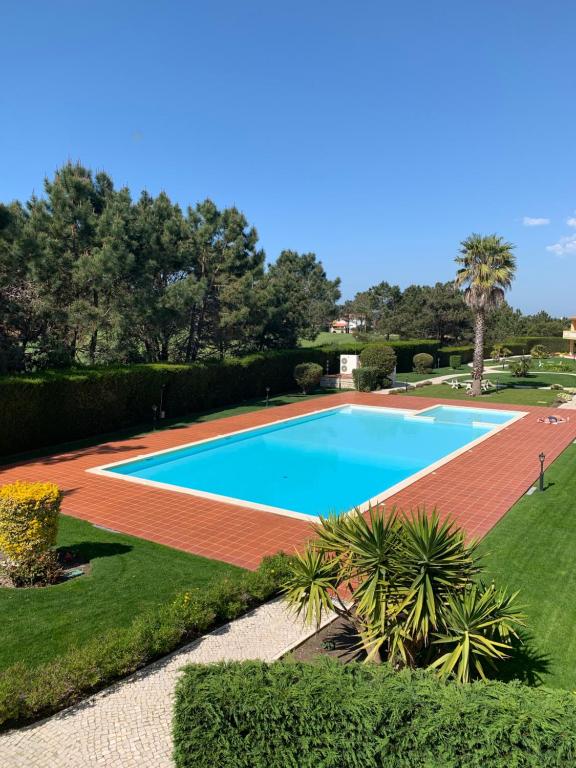 - une vue sur la piscine dans le jardin dans l'établissement T2 Portucale Apartment, à Casal da Lagoa Seca