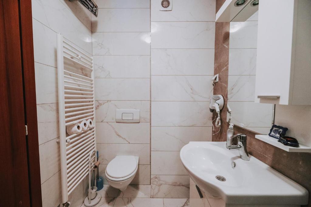a white bathroom with a toilet and a sink at Apartment CITY BanjaLuka - Isaije Mitrovica 3 in Banja Luka