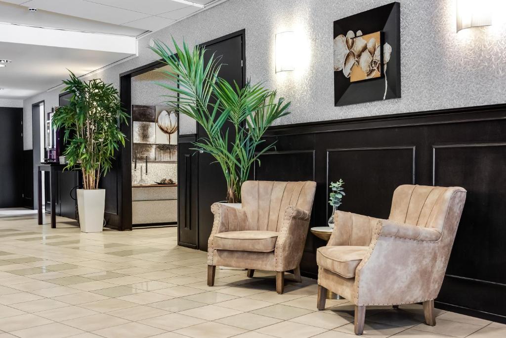 una sala d'attesa con due sedie e piante di Hotel Käenpesä a Ylivieska