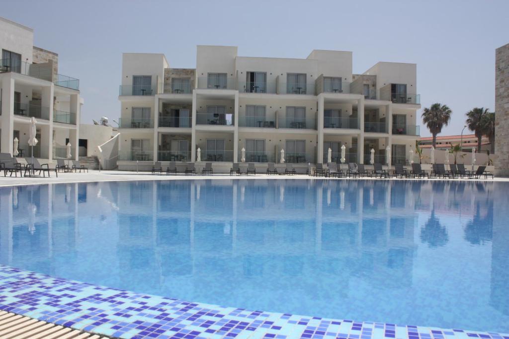 a large swimming pool in front of a building at Amphora Hotel & Suites in Paphos