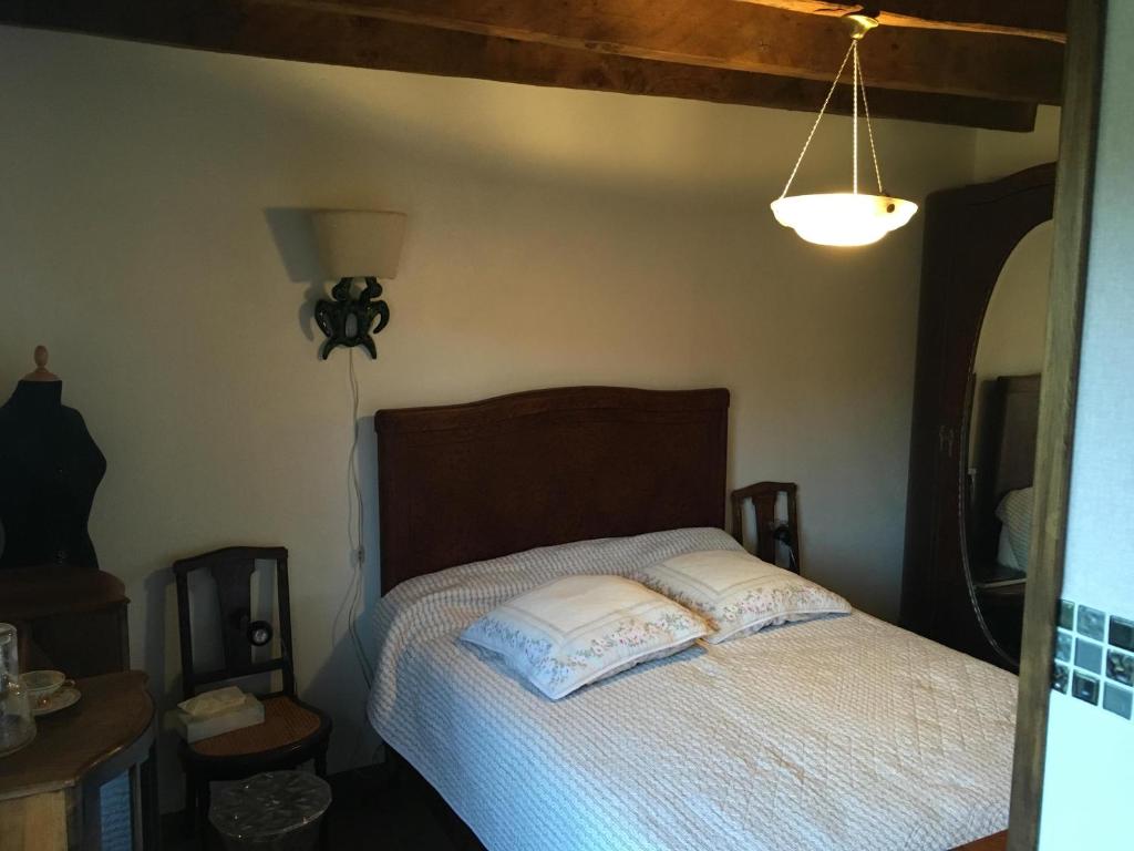 a bedroom with a bed with a wooden headboard at Ma maison de couture in Urval