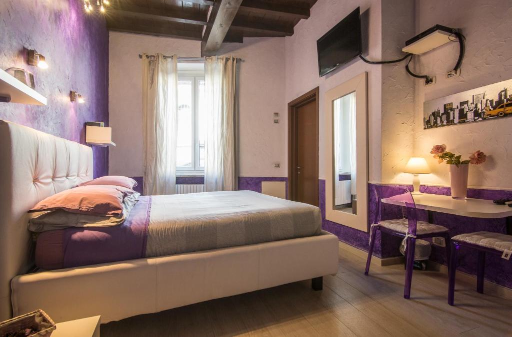 a bedroom with a bed and a table and a window at Bed & Breakfast Parmacentro in Parma