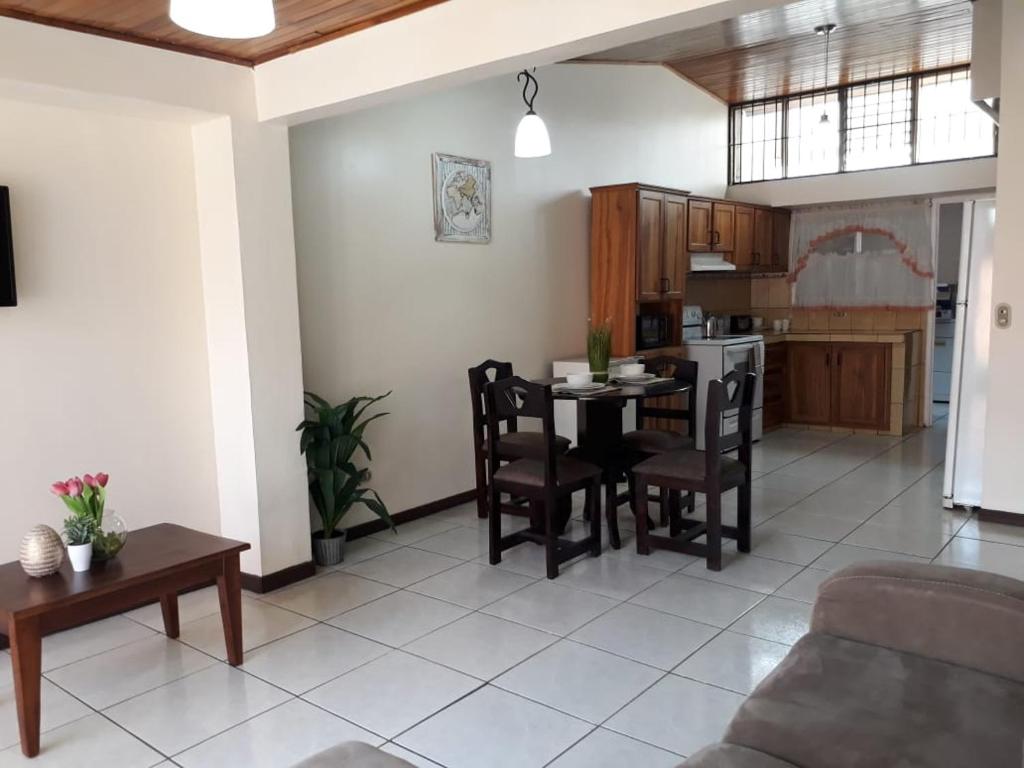 a kitchen and living room with a table and chairs at Kubo Apartment in Alajuela
