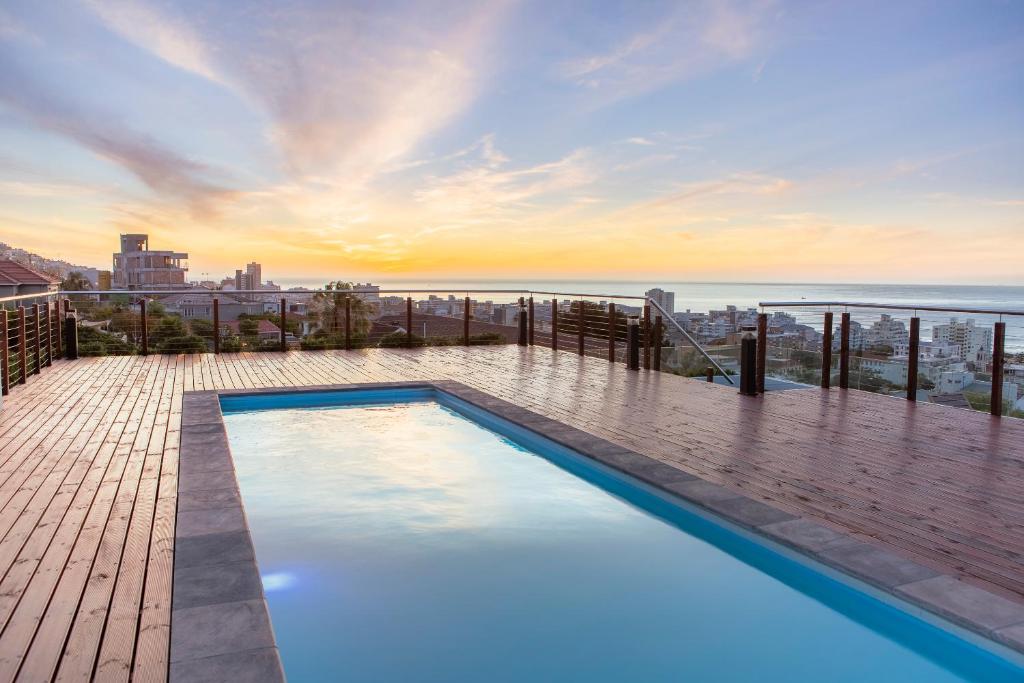 a swimming pool on top of a building with the ocean at Elements Luxury Suites by Totalstay in Cape Town