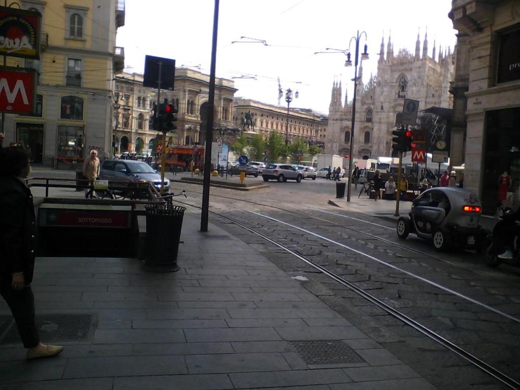 a person standing on a city street with a traffic light at Flat in Milan 1 in Milan