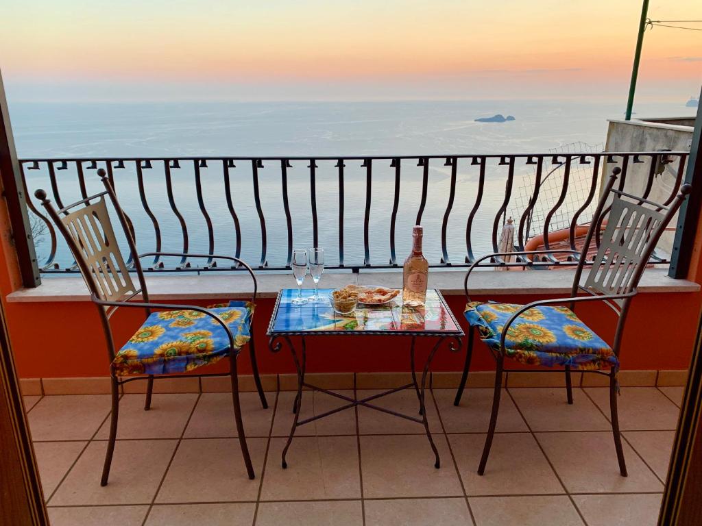 uma mesa e cadeiras numa varanda com vista para o oceano em Anna Apartment em Positano