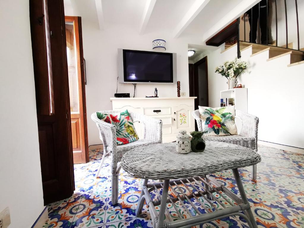 sala de estar con mesa, sillas y TV en Casa Regina, en Lipari