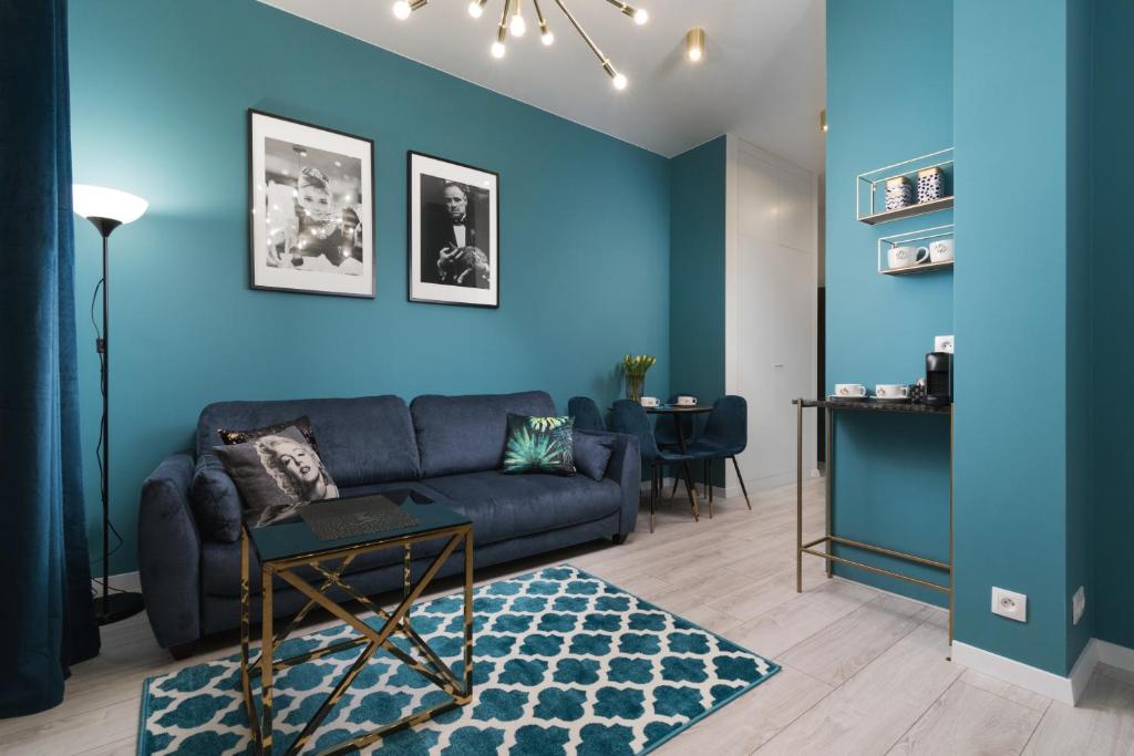 a living room with blue walls and a blue couch at Prime Apartments in Warsaw