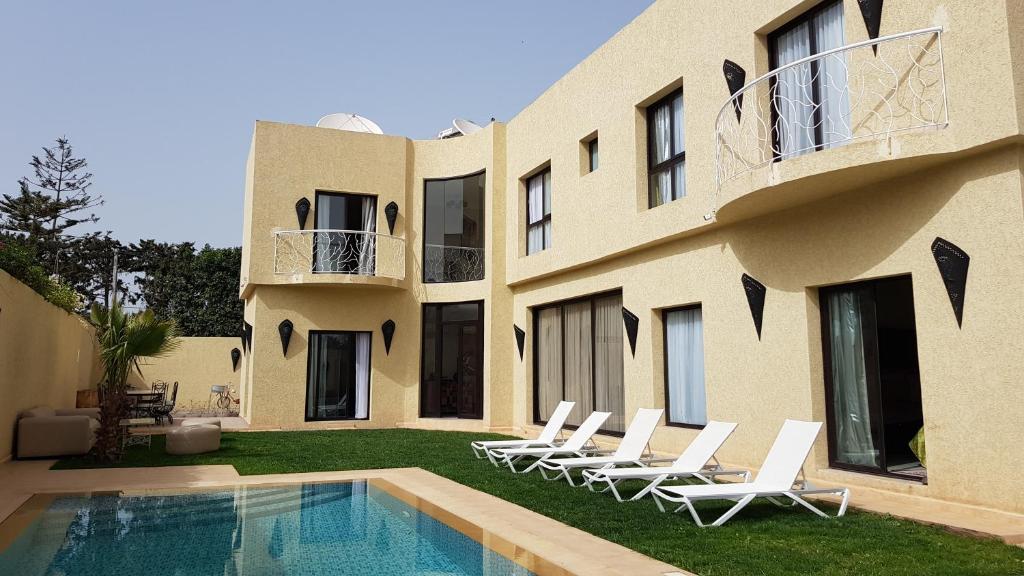 a villa with a swimming pool and lounge chairs at VILLA DARFANI in Agadir