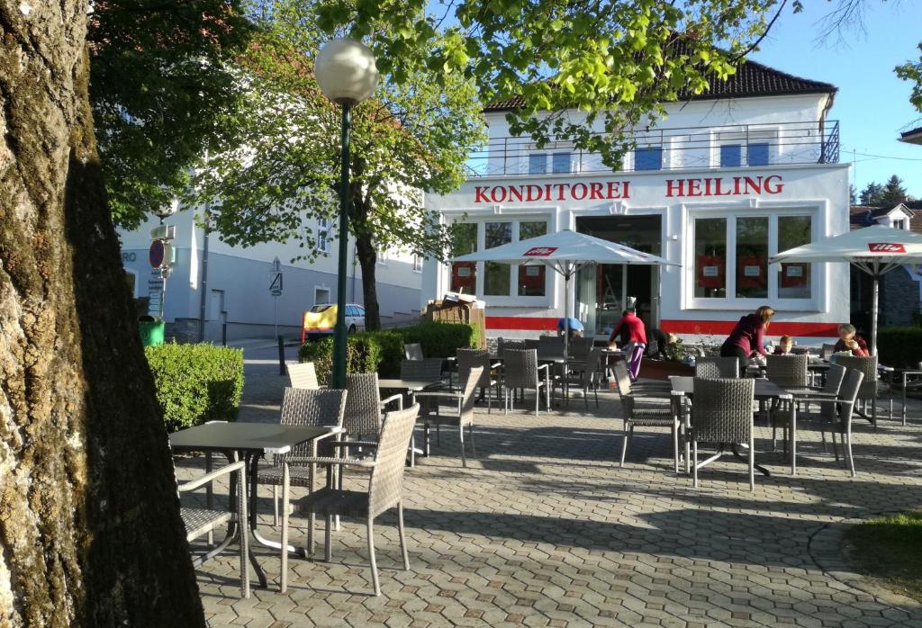 a group of tables and chairs in front of a building at Pension Geschriebenstein in Lochenhaus