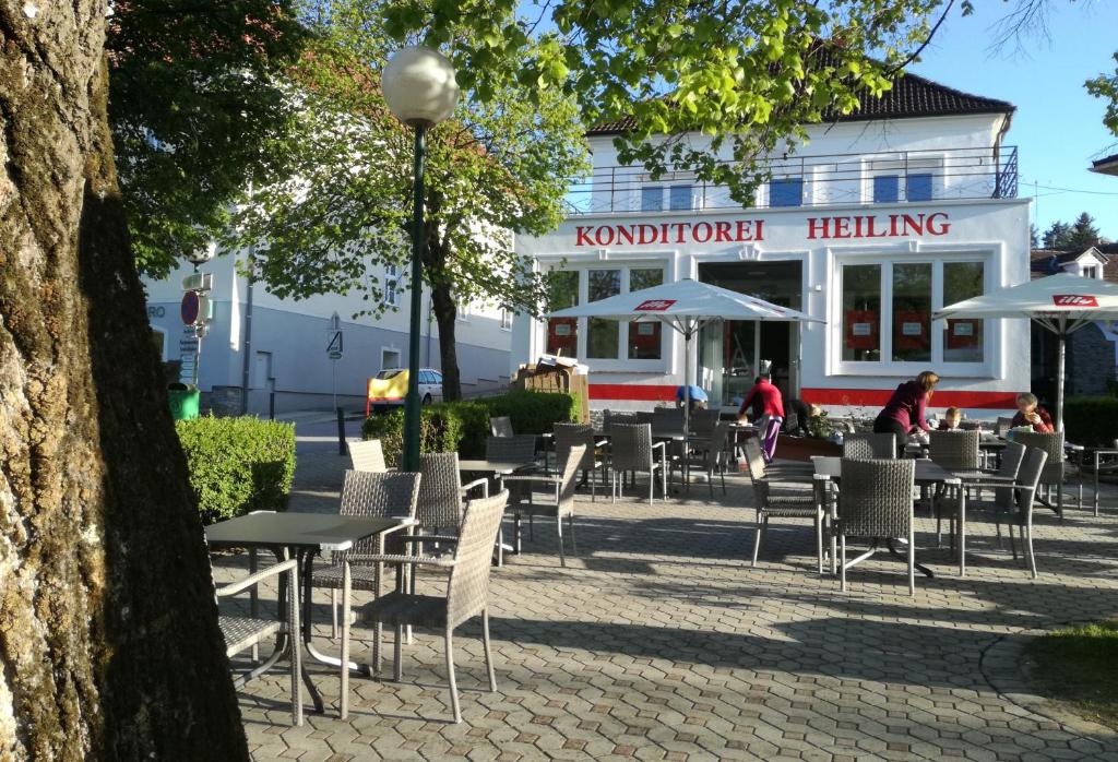 un grupo de mesas y sillas frente a un edificio en Pension Geschriebenstein, en Lochenhaus
