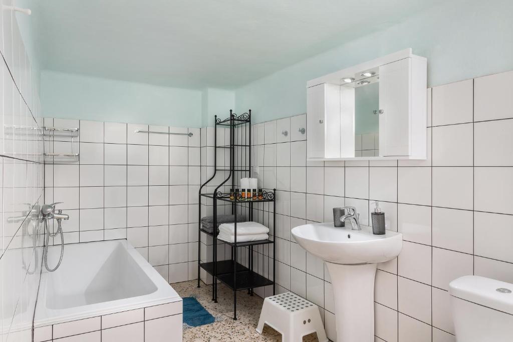 biała łazienka z umywalką i wanną w obiekcie Mampochi Guesthouse w Chanii