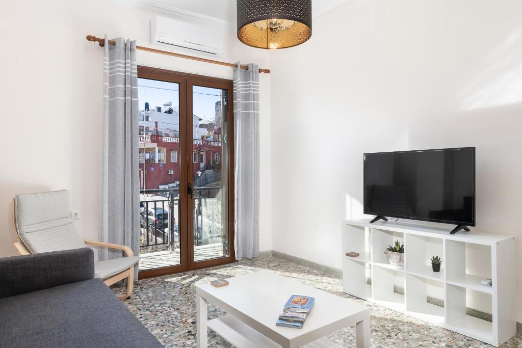 salon z telewizorem i kanapą w obiekcie Mampochi Guesthouse w Chanii