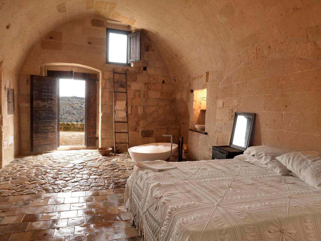 a bedroom with a bed and a tv in it at Sextantio Le Grotte Della Civita in Matera