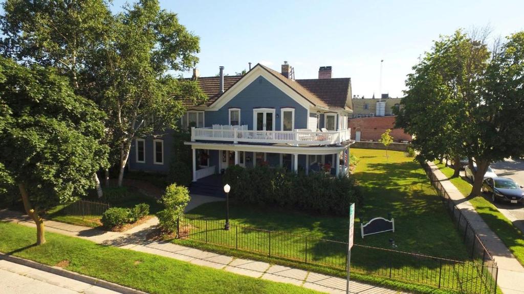 a house with a fence in front of it at The Wanderlust Hotel in Sturgeon Bay