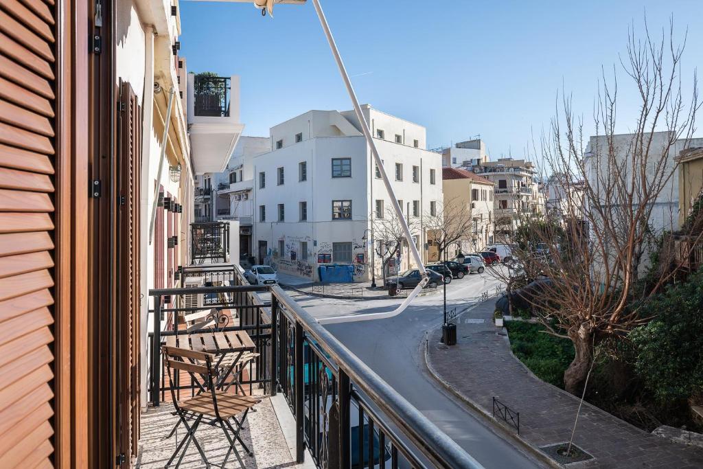 balkon ze stołem i krzesłami przy ulicy miejskiej w obiekcie Mampochi Guesthouse w Chanii