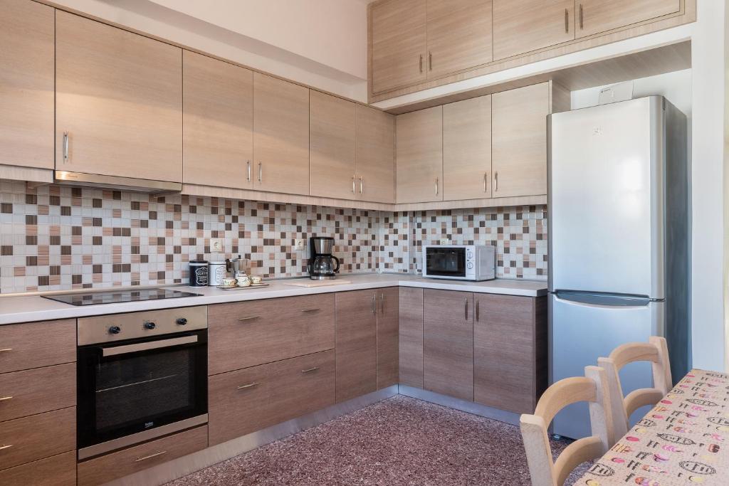 kuchnia z drewnianymi szafkami i lodówką w obiekcie Mampochi Guesthouse w Chanii