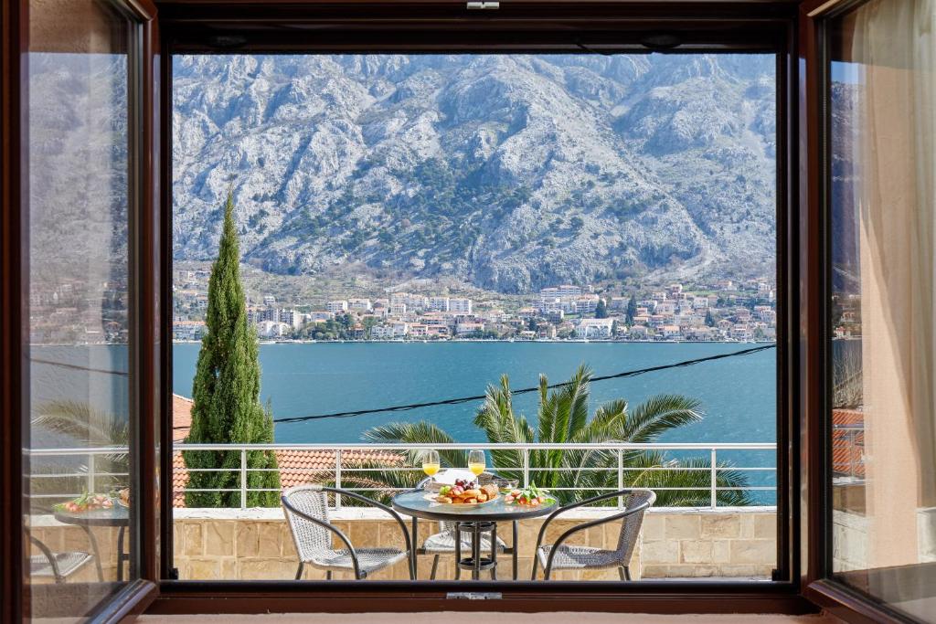 a balcony with a table and chairs and a view of the water at Apartments Barbara in Kotor