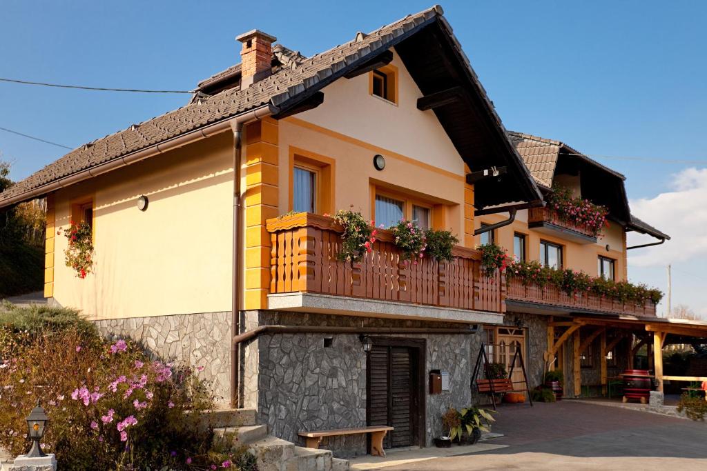 una casa con un balcón con flores. en Tourist Farm Škrbina en Otočec