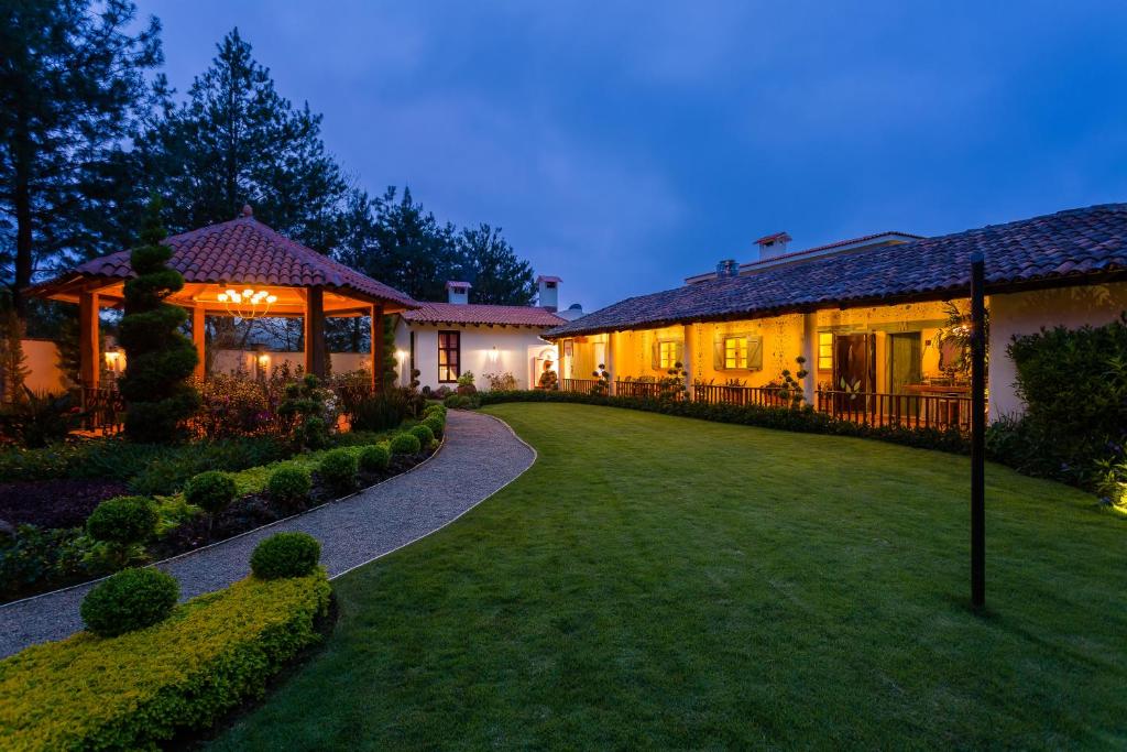 une maison avec une pelouse devant un bâtiment dans l'établissement Villa Nogal Hotel Boutique & Vista, à San Sebastián del Oeste